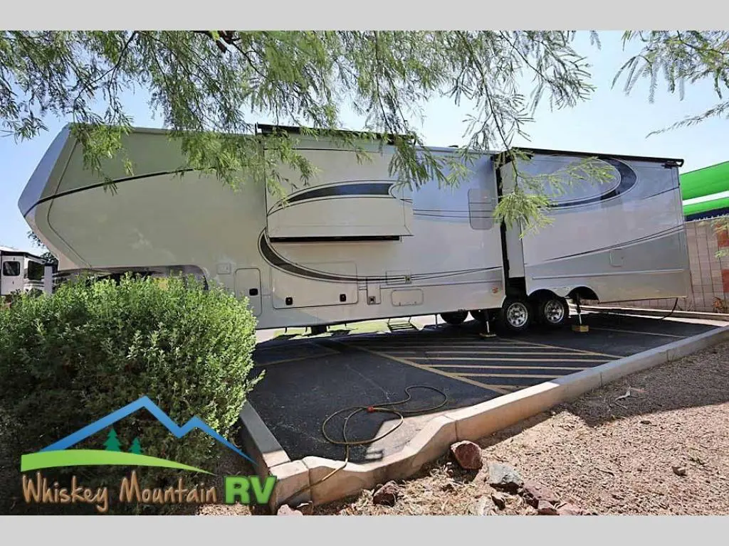 A white rv is parked on the side of a road.